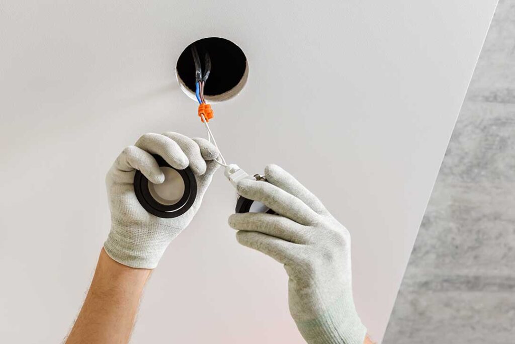 A person's hand resetting a circuit breaker switch in a residential electrical panel.