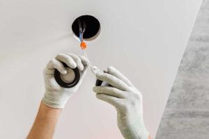 A person's hand resetting a circuit breaker switch in a residential electrical panel.